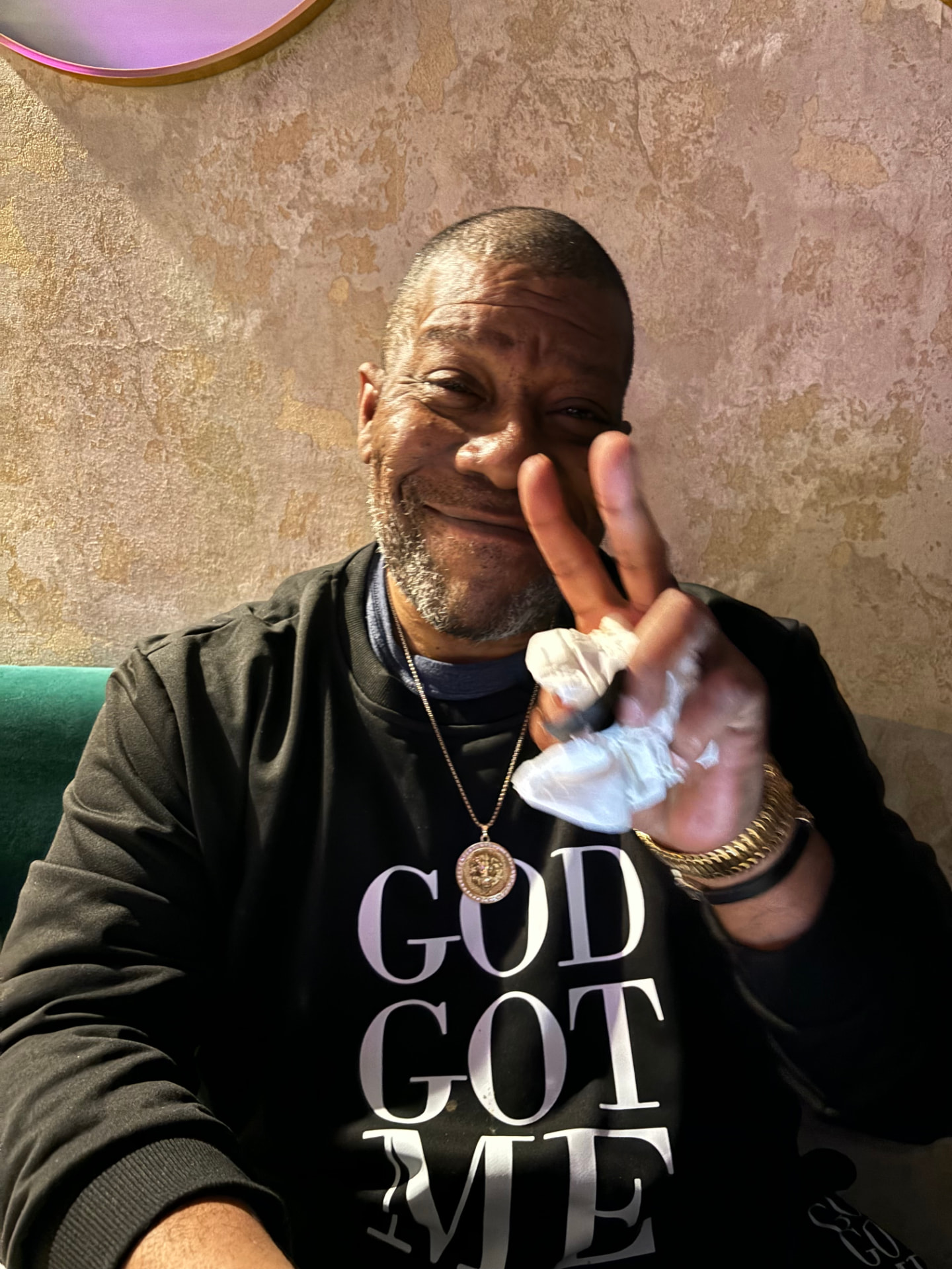 Norman C. Winston smiling and giving a peace sign